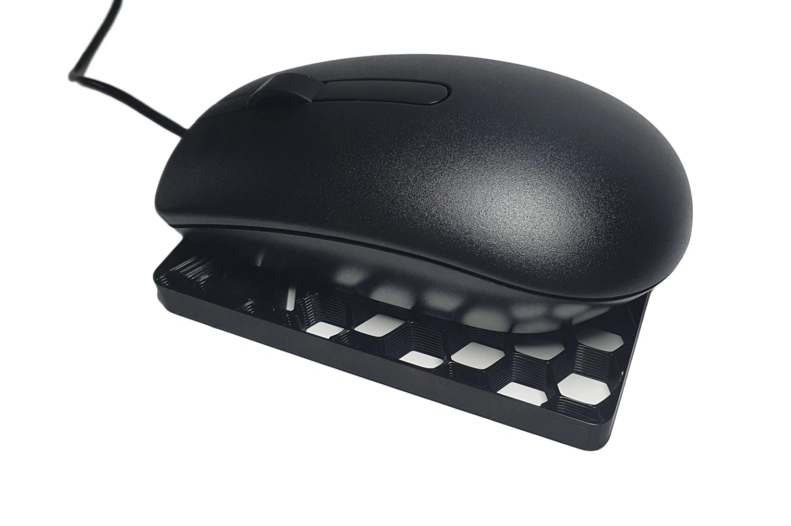 A wired mouse resting on the mechanical Mouse Jiggler device. Mouse not included.